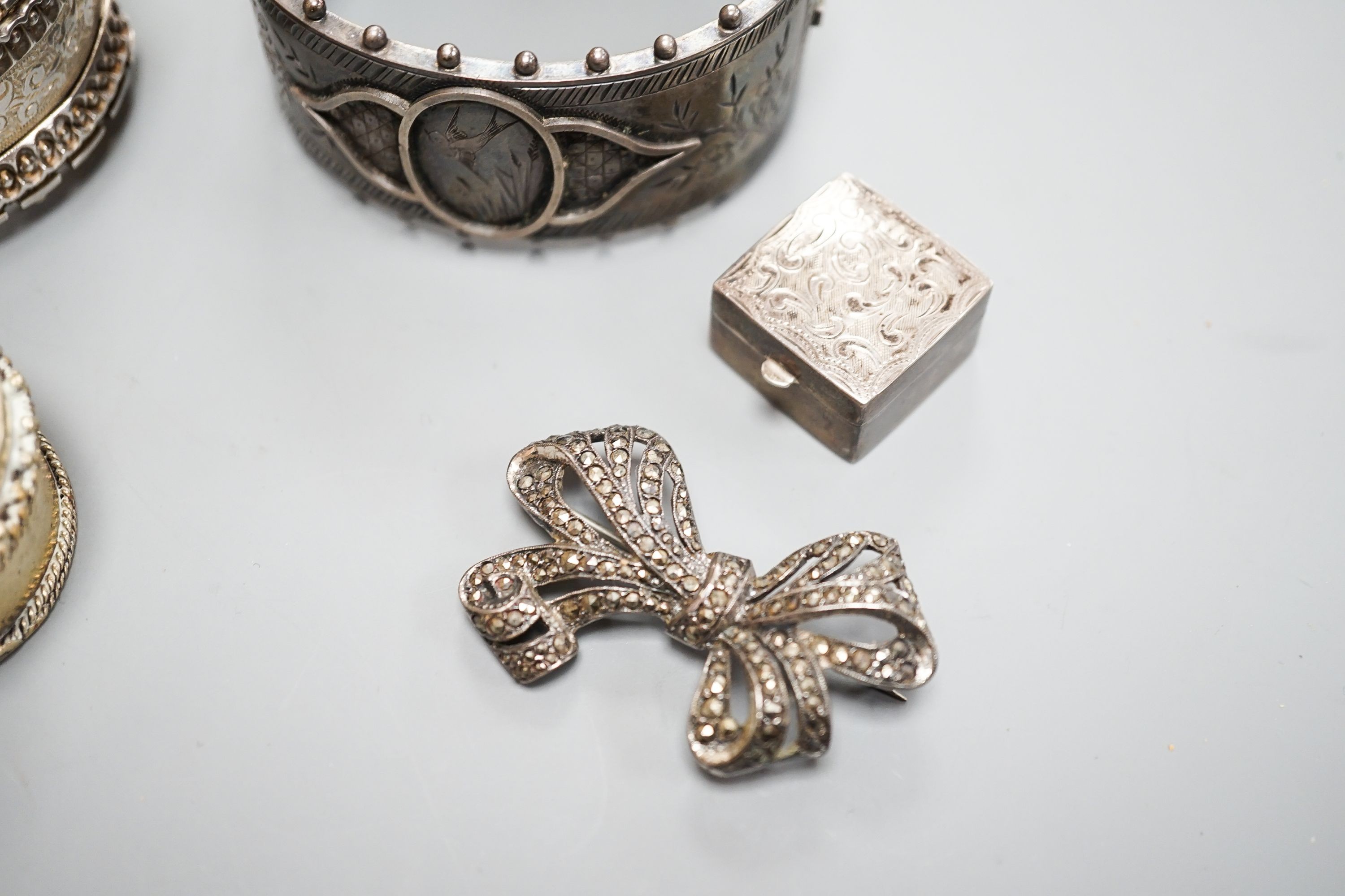 Two white metal bangles including sterling, a marcasite brooch, gem set yellow metal ring and other minor items.